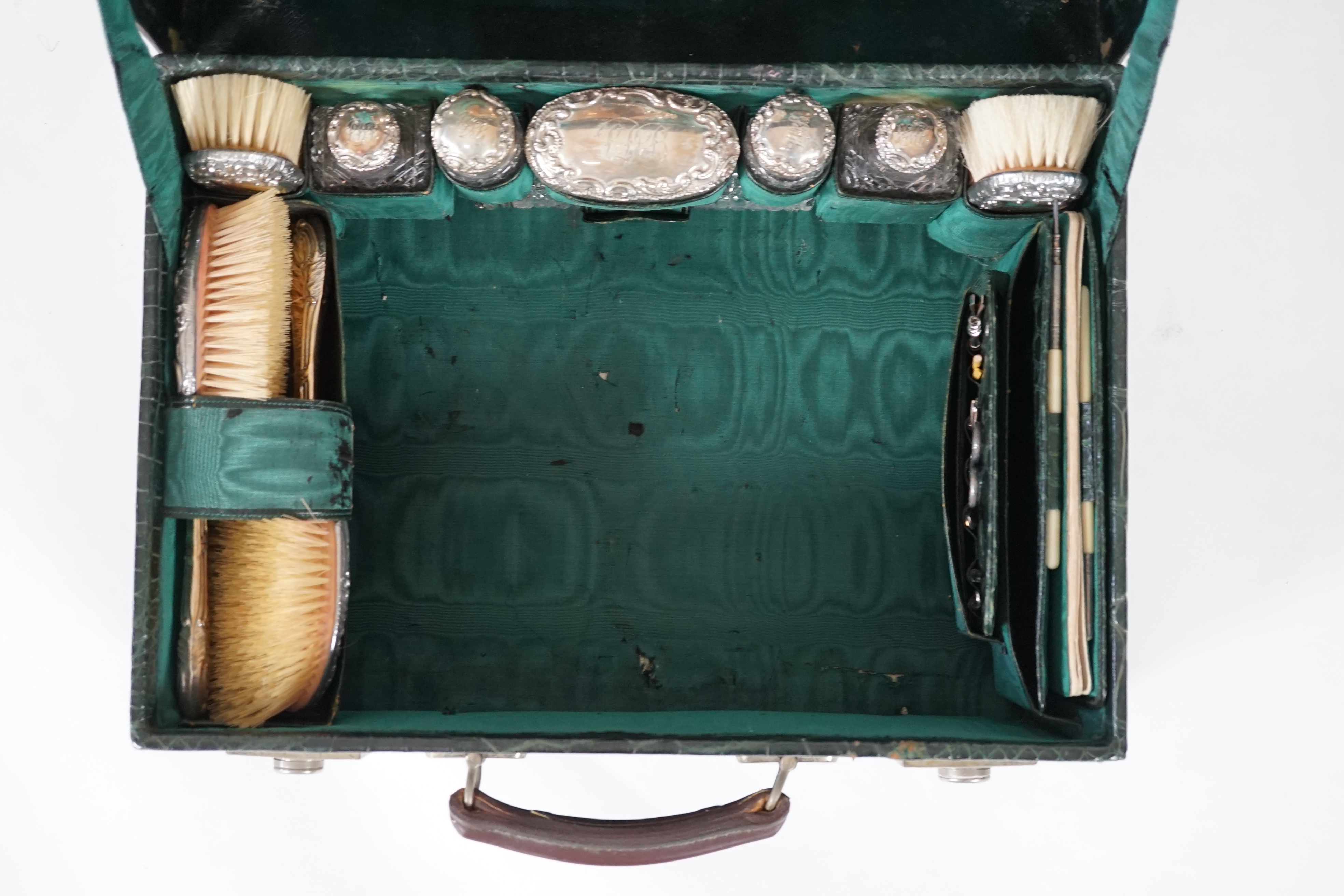 A George V green crocodile toilet case, 46cm x 33cm x 18cm